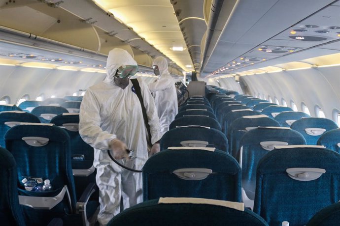 03 March 2020, Vietnam, Hanoi: Members of staff of the Center for Disease Control in Hanoi spray disinfectant inside a plane at Noi Bai International Airport amid the outbreak of Covid-19 (coronavirus). Vietnam Airlines on Monday agreed to stop all flig