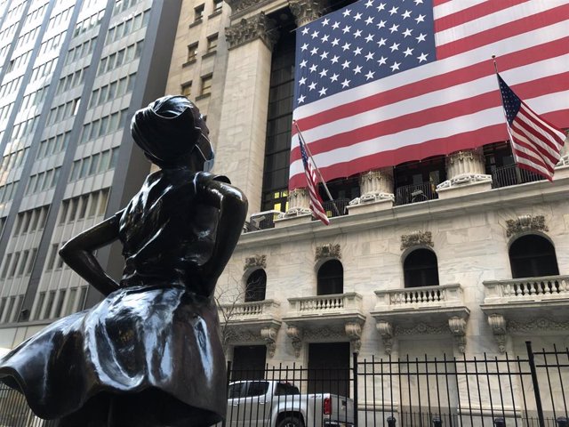 15 April 2020, US, New York: The Fearless Girl bronze statue is seen wearing a surgical mask on Wall Street amid the coronavirus pandemic. Photo: Benno Schwinghammer/dpa