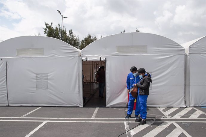 15 January 2021, Ecuador, Quito: Two patients check their PCR results outside the improvised tents in front of the Iess South Hospital were tested for the coronavirus. Photo: Juan Diego Montegro/