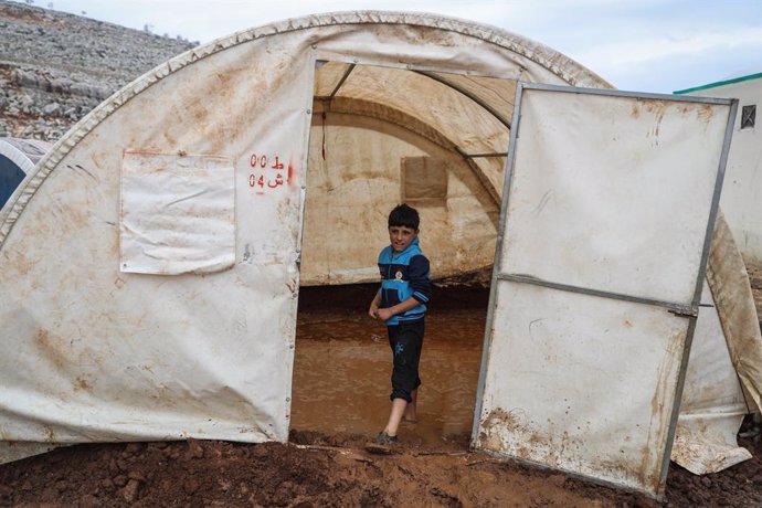 16 January 2021, Syria, Sarmada: A Syrian boy stands at the entrance of a tent flooded with rain water at the Baraem camp for internally displaced people. Photo: Anas Alkharboutli/dpa