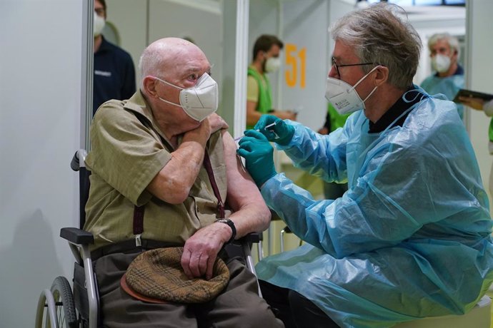 18 January 2021, Berlin: Herri Rehfeld (L), 92 years old, receives the coronavirus (Covid-19) vaccine at the vaccination centre on the Berlin exhibition grounds. Photo: Sean Gallup/Getty Images Europe/Pool/dpa