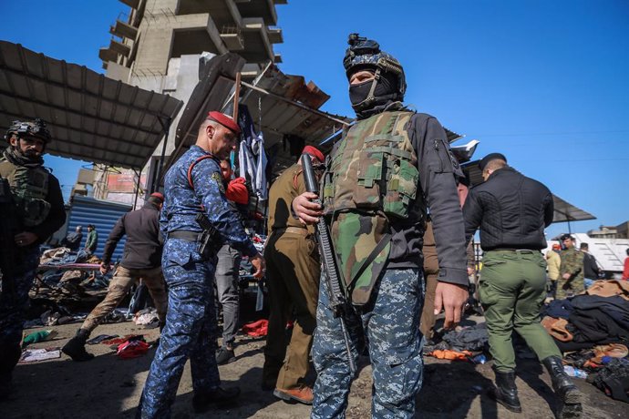 21 January 2021, Iraq, Baghdad: Members of Iraqi security forces gather at the scene of a twin suicide attack in a street market selling used clothes in central Baghdad. At least 28 people were killed and more than 70 were injured in a twin suicide atta
