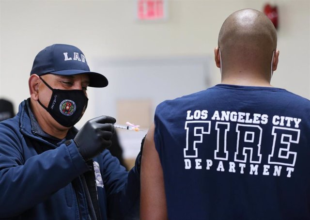 Un miembro del Departamento de Bomberos de Los Ángeles se vacuna contra el coronavirus.