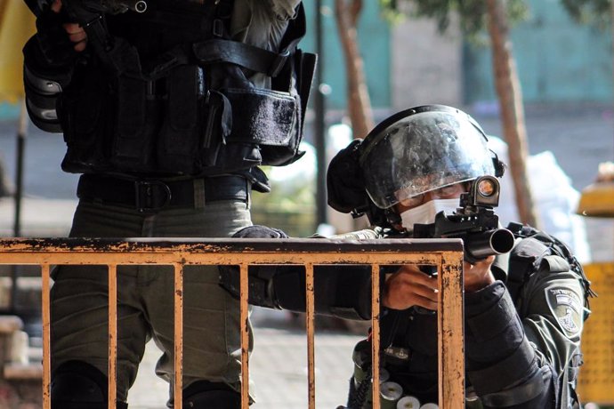 30 October 2020, Palestinian Territories, Hebron: An Israeli soldier takes aim at Palestinian protesters during clashes following a demonstration against the expropriation of Palestinian land by Israeli authorities, in the West Bank city of Hebron. Phot