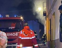 Un bombero entra en la vivienda en llamas.