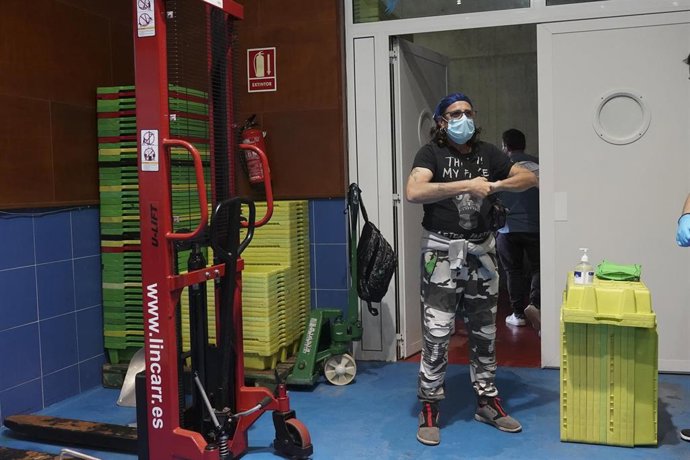 Un pescador se limpia las manos con hidrogel antes de someterse a un test rápido de Covid 19 en la costera del bocarte de 2020