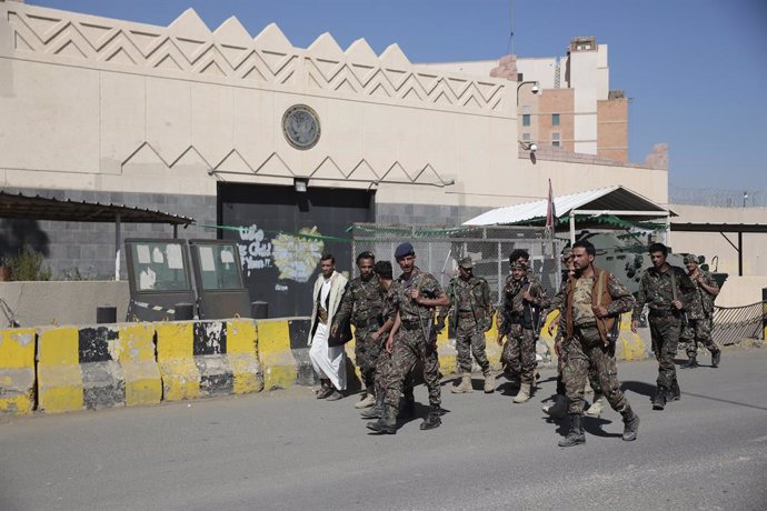 18 January 2021, Yemen, Sanaa: Houthi soldiers walk past the USembassy in Sanaa during a protest against the United States over its decision to designate the Houthi rebels movement as a foreign terrorist organization. Photo: Hani Al-Ansi/dpa