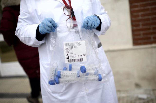 Un sanitario con tubos de ensayo durante la realización de tests de RT-PCR.