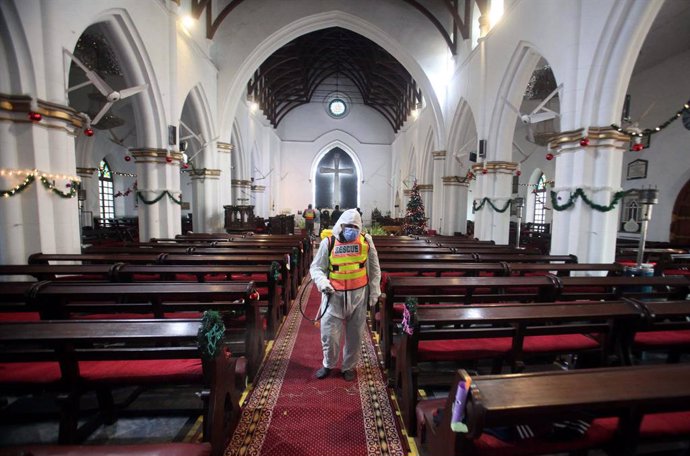 24 December 2020, Pakistan, Peshawar: A rescue worker sprays chlorine water at all the areas for disinfecting as a preventive measure against the coronavirus (Covid-19), ahead of the Christmas eve mass at St. John's Cathedral Church. Photo: -/PPI via ZU