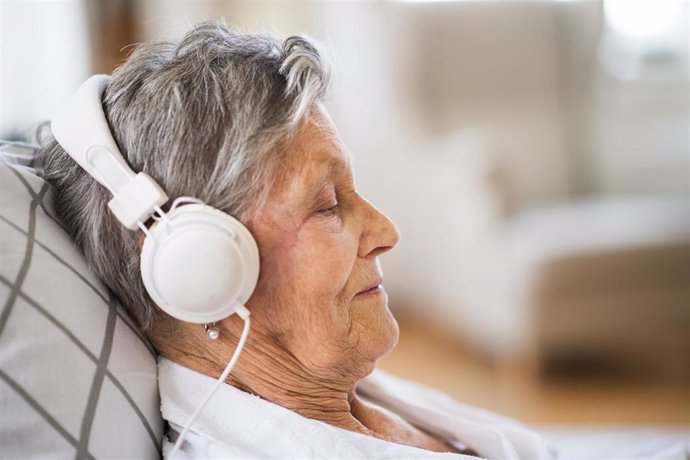 Mujer mayor escuchando música.