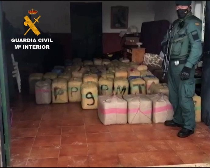 Un agente de la Guardia Civil custodia los kilogramos incautados en la operación Impasible desarrollada en Málaga y Cádiz