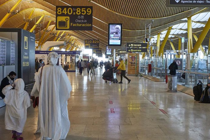Varios pasajeros caminan por las instalaciones de la Terminal 4 del aeropuerto Madrid-Barajas Adolfo Suárez, en Madrid (España), a 12 de enero de 2021.  