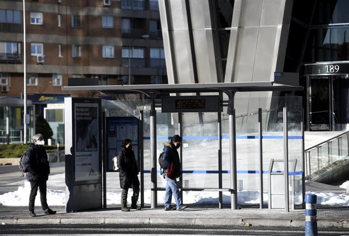 Varias personas esperando el autobús en Madrid (España), a 18 de enero de 2021