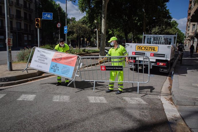 Empleados instalan vallas para cortar el tráfico lateral de la Diagonal (Diagonal-Sant Joan), una de las medidas establecidas por el Ayuntamiento de Barcelona para ampliar los espacios destinados a los peatones, mejorar la red de bus y ampliar las vías 
