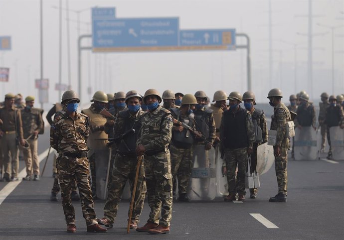 Agentes de las fuerzas de seguridad indias desplegados con mascarilla en Nueva Delhi frente a una protesta de agricultores