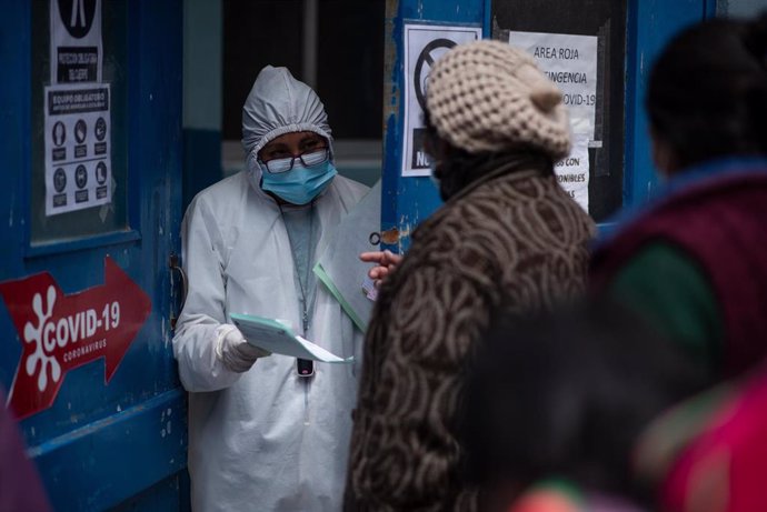 Una trabajadora sanitaria habla con personas en La Paz, Bolivia, durante la pandemia de COVID-19. 