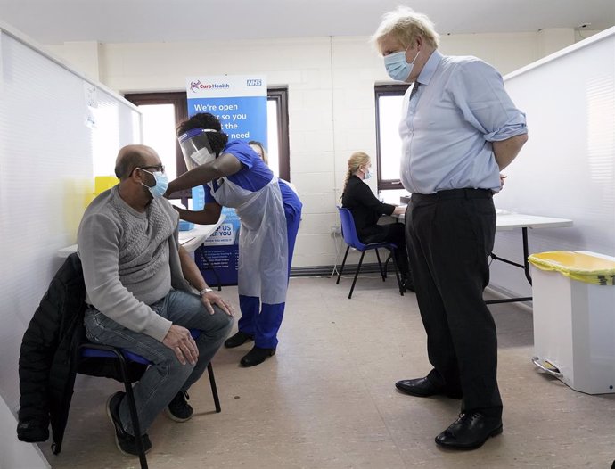 01 February 2021, United Kingdom, Batley: UK Prime Minister Boris Johnson (R) watches as doctor Chantelle Ratcliffe injects the vaccine to Ismail Patel during a visit to a coronavirus vaccination centre. Photo: Jon Super/PA Wire/dpa