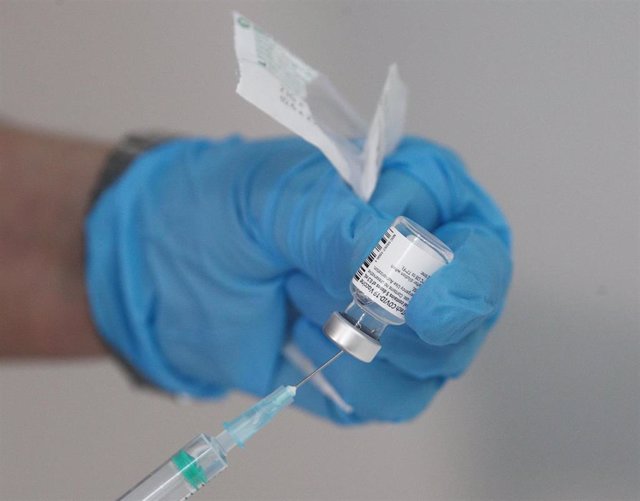 Un enfermero prepara una vacuna antes de inyectársela a un trabajador sanitario en las instalaciones del Hospital Enfermera Isabel Zendal.
