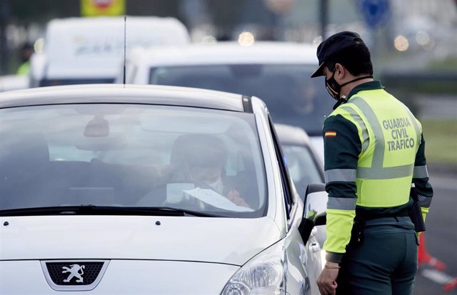 Un agente de la Guardia Civil le pide la documentación al conductor de un vehículo durante un control efectuado en Laredo, Cantabria, (España), a 28 de enero de 2021. 