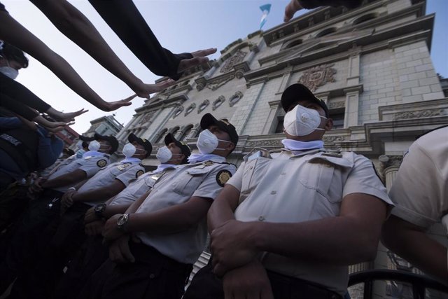 Agentes de la Policía de Guatemala con mascarilla frente al Palacio Nacional  en un día de protestas.