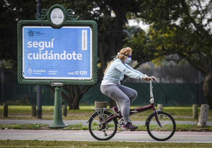 Una mujer con mascarilla pasea en bicicleta.