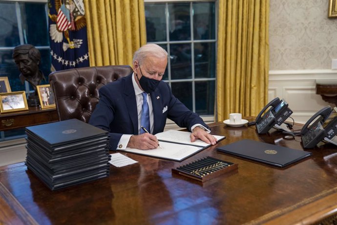 January 20, 2021 - Washington, DC, United States:  United States President Joe Biden signs executive order on Covid-19 during his first minutes in the Oval Office, Wednesday, Jan. 20, 2021. President Biden as the 46th president of the United States. (Do
