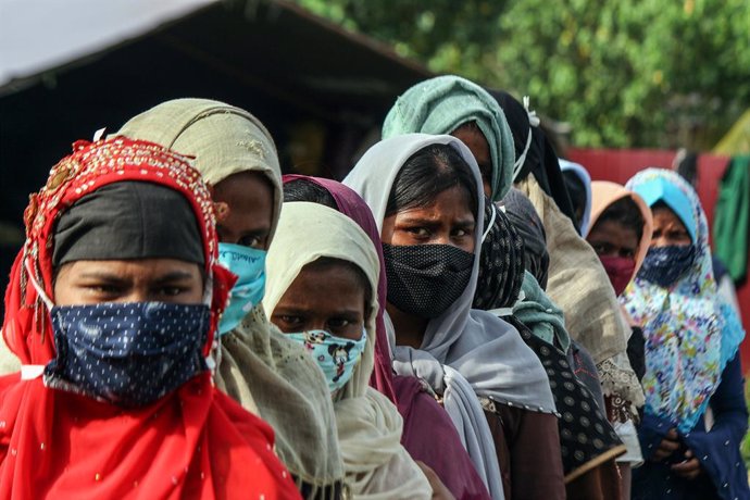 Refugiadas rohingyas con mascarilla hacen cola para un chequeo médico en Indonesia