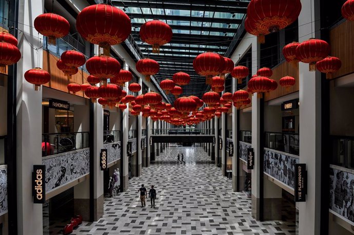 27 January 2021, Malaysia, Kuala Lumpur: People walk beneath decorative Chinese lanterns that have been hung at a shopping mall in preparation for the Chinese New Year celebrations, scheduled to take place on 12 February 2021. Photo: Amirul Azmi/BERNAMA