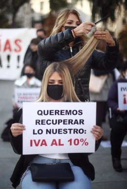 Una peluquera corta el pelo a una mujer durante una concentración frente al Congreso de los Diputados, en Madrid (España) 