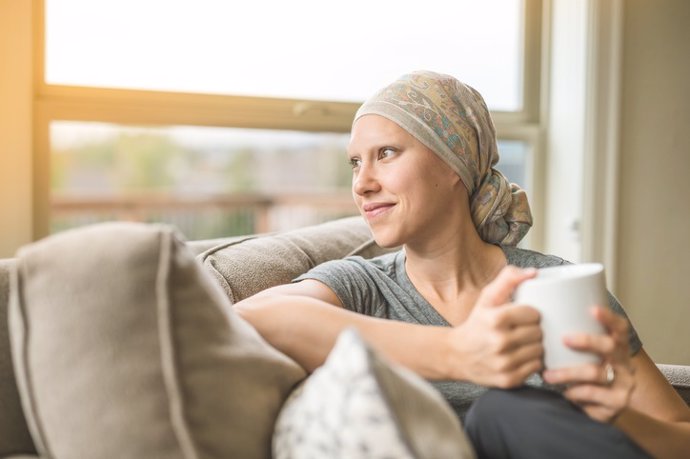 Ethnic young adult female cancer patient sipping tea