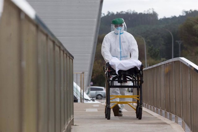 Un trabajador sanitario totalmente protegido traslada una camilla en las inmediaciones de la residencia de ancianos de San Cibrao donde se ha originado un brote de Covid-19, en San Cibrao, Lugo, Galicia, (España), a 9 de noviembre de 2020. En el centro 