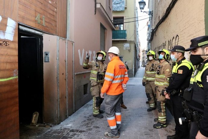 Efectivos de la Policía Local y del Cuerpo de Bomberos inspeccinan el edificio incendiado de la calle Cerezo, 41 de Zaragoza antes de tapiarlo