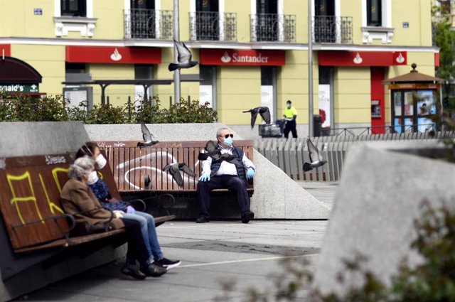 Personas sentadas en la plaza Felipe II del distrito de Salamanca. 
