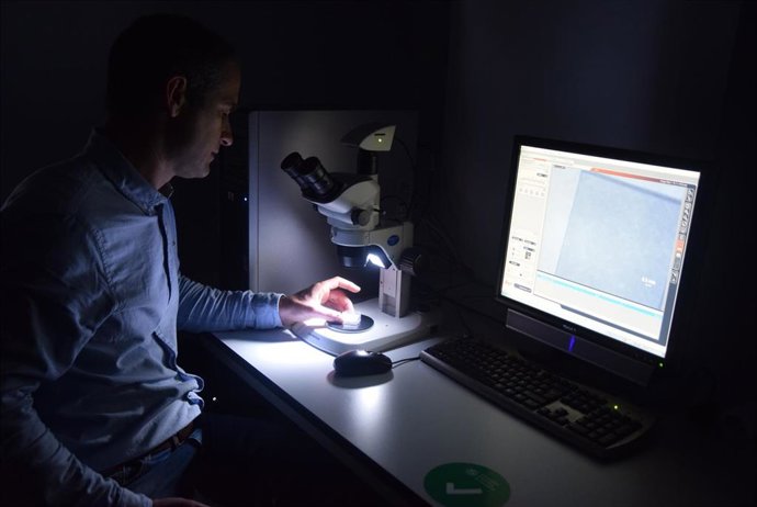El investigador de la UPCT Javier Prior observando con una lupa de microscopio el diamante que utiliza para mejorar la resolución de las resonancias magnéticas