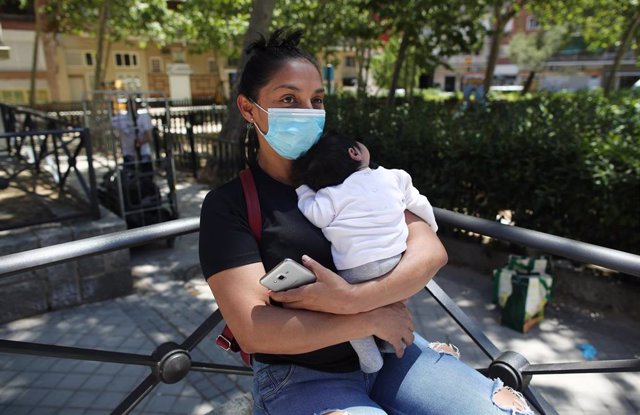 Lucía, una mujer con su bebé en brazos, acude a las puertas de la Parroquia Santa María Micaela para recibir una ayuda alimentaria.