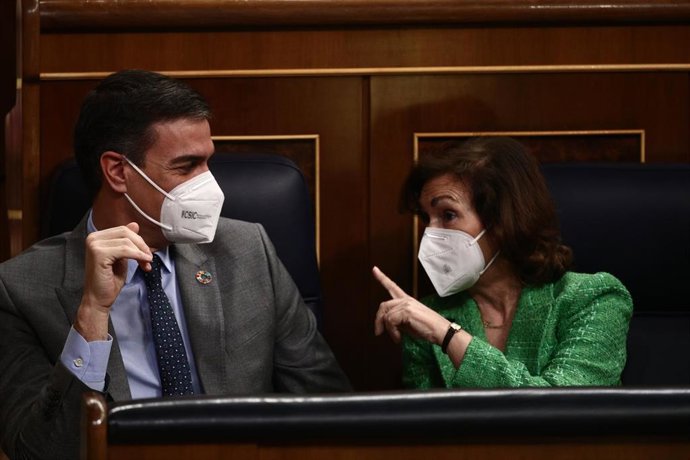 El presidente del Gobierno, Pedro Sánchez, conversa con la vicepresidenta primera del Gobierno, Carmen Calvo, durante la primera sesión de control al Gobierno de 2021 celebrada en el Congreso de los Diputados, en Madrid, (España), a 3 de febrero de 2021