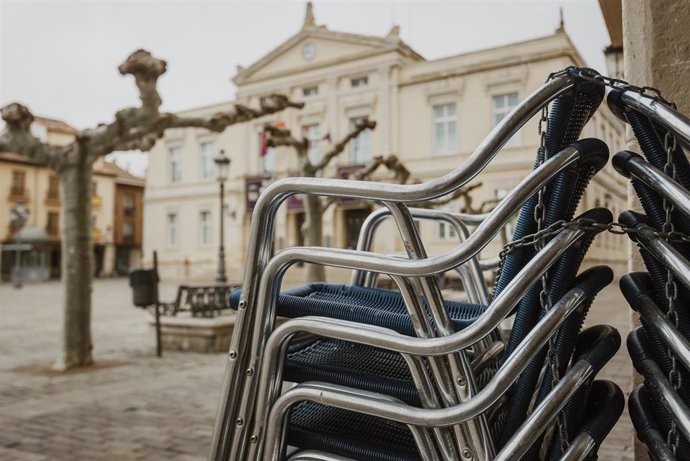 Las sillas de una terraza apiladas durante el primer día del cierre de la hostelería en Palencia, Castilla y León 