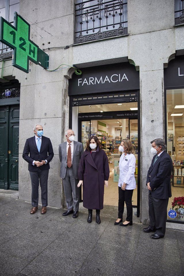 El consejero madrileño de Sanidad, Enrique Ruiz Escudero (1i), y la presidenta de la Comunidad de Madrid, Isabel Díaz Ayuso (centro), durante una visita una farmacia de la capital, en Madrid (España), a 2 de febrero de 2021. Ayuso ha querido conocer de pr