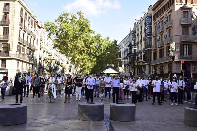Asistentes guardan un minuto de silencio en recuerdo a las 16 personas fallecidas el 17 de agosto de 2017 y a los más de 150 heridos en los atentados de Barcelona y Cambrils durante el homenaje celebrado en Las Ramblas con motivo del tercer aniversario 