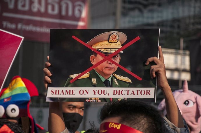01 February 2021, Thailand, Bangkok: Ademonstrator holds a crossed-out poster of Myanmar's army chief Min Aung Hlaing during a protest outside Myanmar's embassy in Bangkok, after Myanmar's military seized power from the de facto leader Aung San Suu Kyi