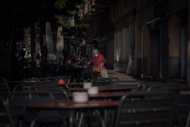 Una mujer en una terraza durante el primer día del inicio del primer tramo de la desescalada de la segunda ola por el coronavirus en Barcelona, Catalunya (España), a 23 de noviembre de 2020. Desde hoy, bares y restaurantes podrán abrir de 6.00 a 21.30 par