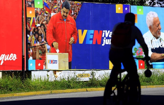 Un cartel con Nicolás Maduro depositando el voto
