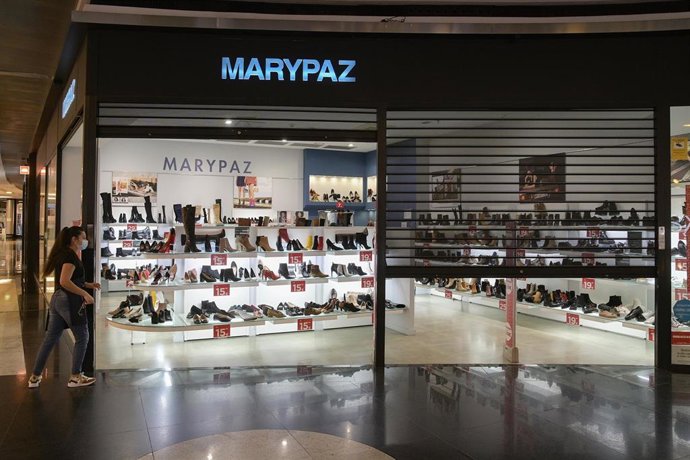 Una dependienta de la zapatería MARYPAZ cierra el establecimiento en el centro comercial Marineda, el día de la entrada en vigor de una nueva restricción que obliga a cerrar el comercio no esencial a las 18.00 horas, en A Coruña, a 27 de enero de 2021. 