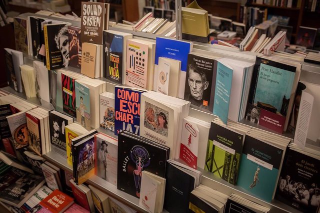 Libros y material colocado en las estanterías de la librería Laie Pau Claris librería-café ubicada en la calle catalana de Pau Claris, donde los trabajadores preparan libros y material antes de enviarlos