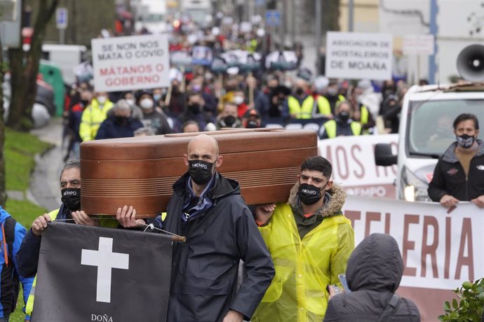 Trabajadores del sector hostelero sostienen una lpida frente a la Xunta de Galicia como signo de protesta, en Santiago de Compostela, A Coruña, Galicia, (España),  