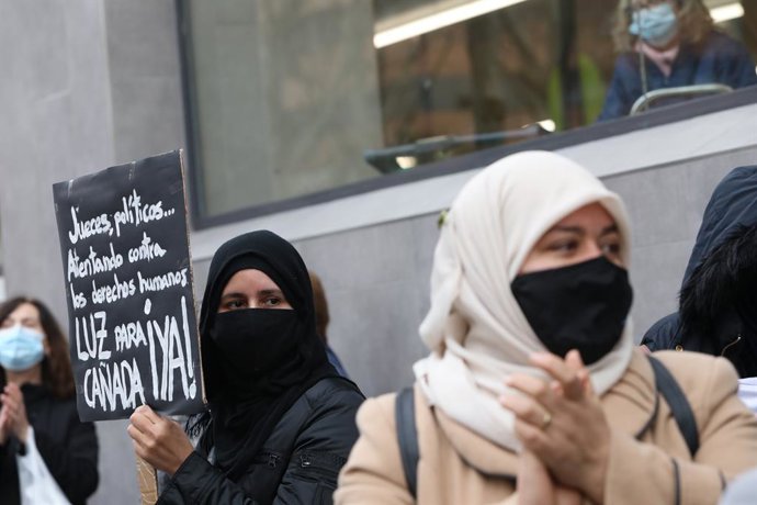Una mujer sostiene una pancarta donde se lee "Luz para Cañada Real ¡YA!!" durante una manifestación de vecinos de los sectores V y VI de la Cañada Real Galiana frente a la Asamblea de Madrid (España), a 4 de febrero. Con su protesta, los vecinos reclama