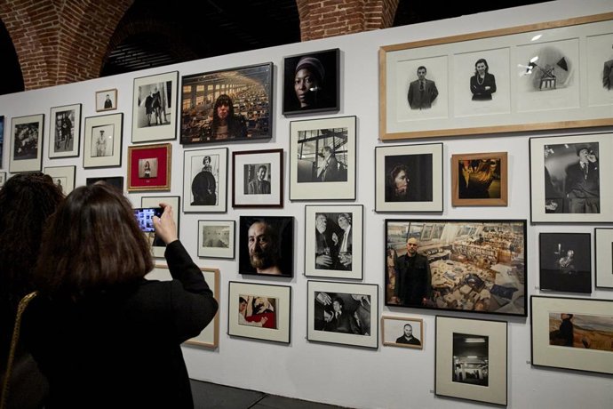 Varias personas visitan la exposición 'Arco. Recorridos Fotográficos' en Condeduque, en Madrid (España).