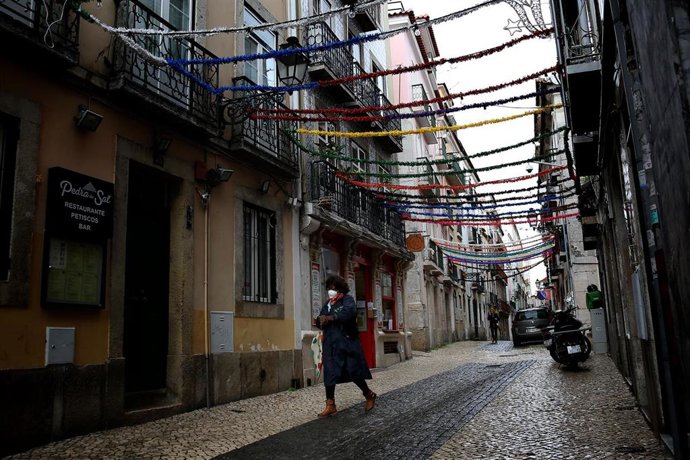 Una mujer con mascarilla pasea por Lisboa