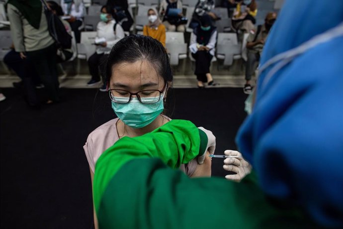 04 February 2021, Indonesia, Jakarta: Ahealth worker receives the first dose of the Coronavirus (Covid-19)vaccine in a mass vaccination centre mounted at the Istora Stadium by the Ministry of Health. Over 600 thousand health workers received the first