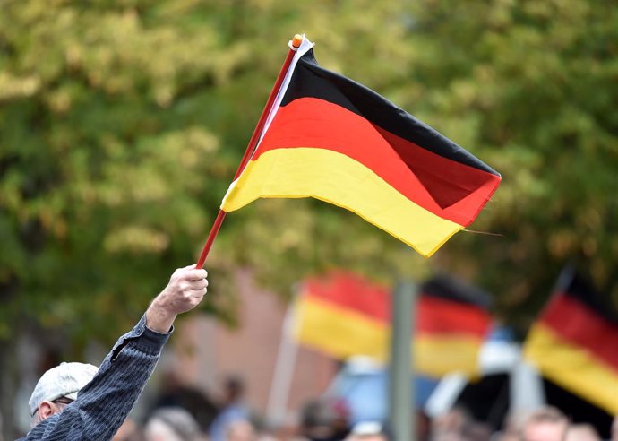 08 September 2019, North Rhine-Westphalia, Moenchengladbach: A demonstrator waves a German flag at the rally of right-wing groups. A large contingent of the police accompanied a rally of right-wing groups and the counter-demonstration of predominantly b